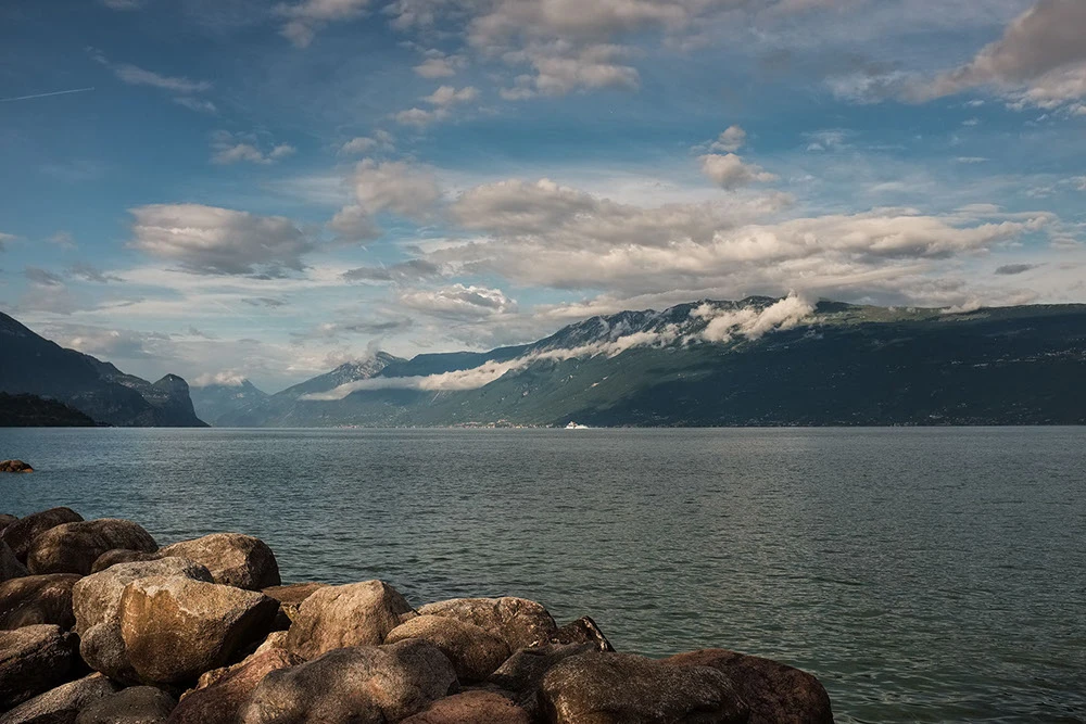 Foto del lago di Garda visto dalla riva, sullo sfondo il monte Baldo e la costa veronese
